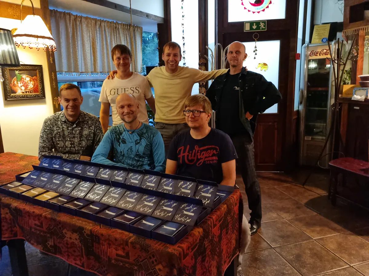 The six people who make up Plepic Games, photographed together indoors with copies of the Lunar Base box on the table in front of them.